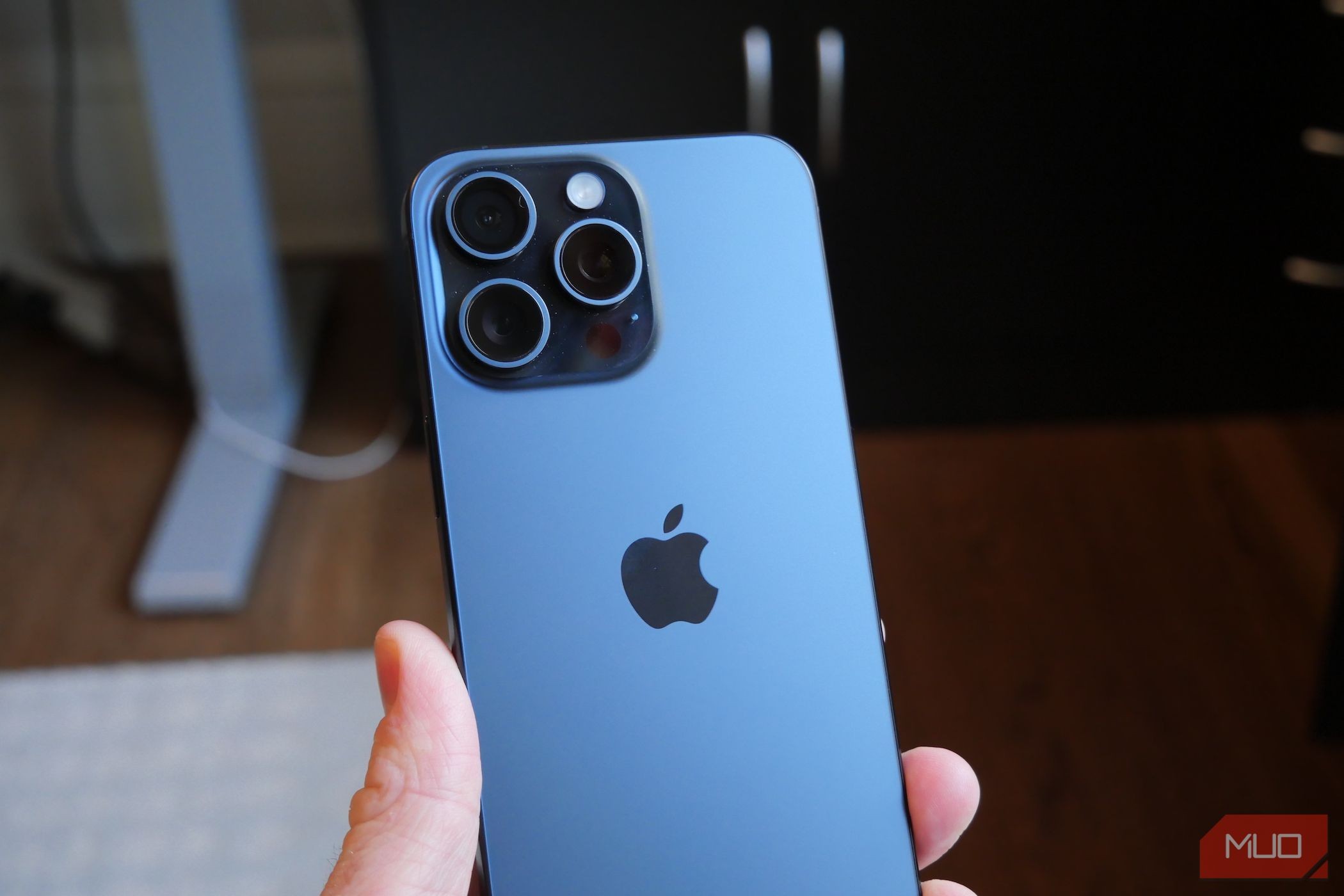 A man holding an iPhone 15 Pro Max showing its back