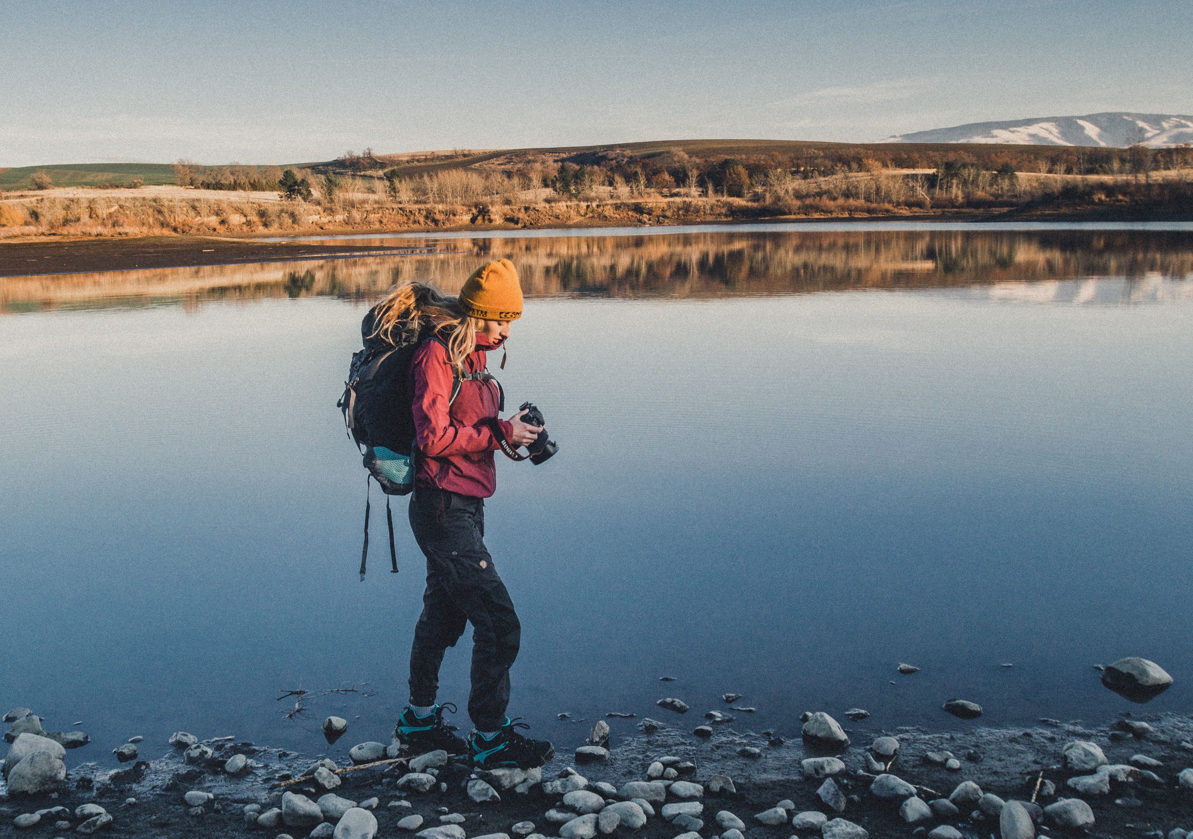 A woman hiking and looking at her camera