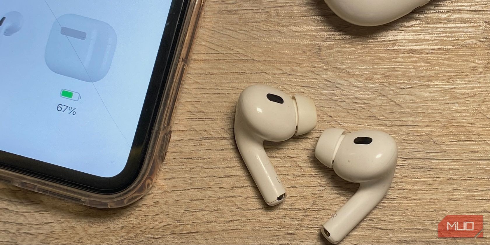 AirPods trên bàn gỗ bên cạnh iPhone