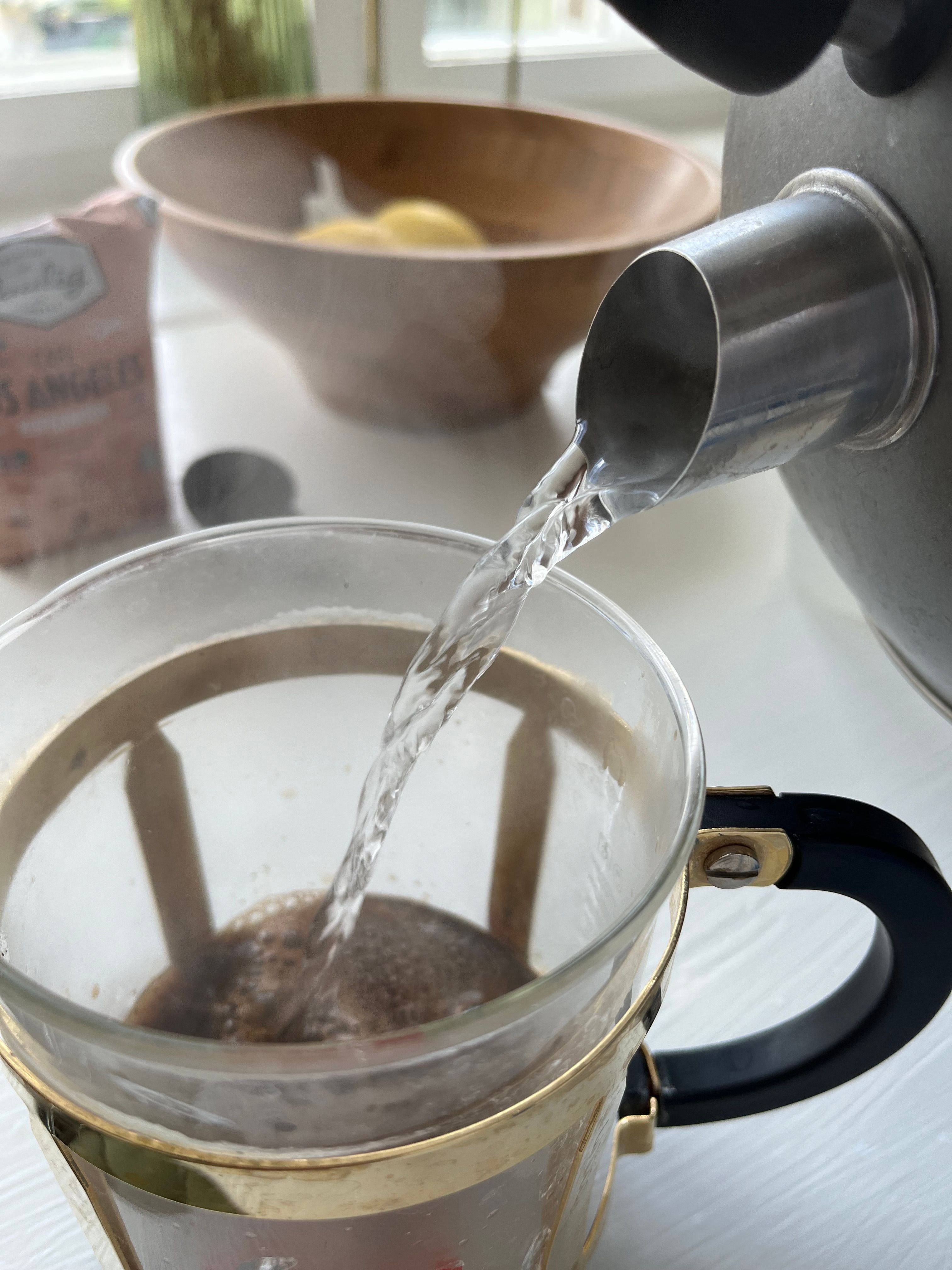 Ảnh chụp nước đổ từ ấm vào máy ép cà phê