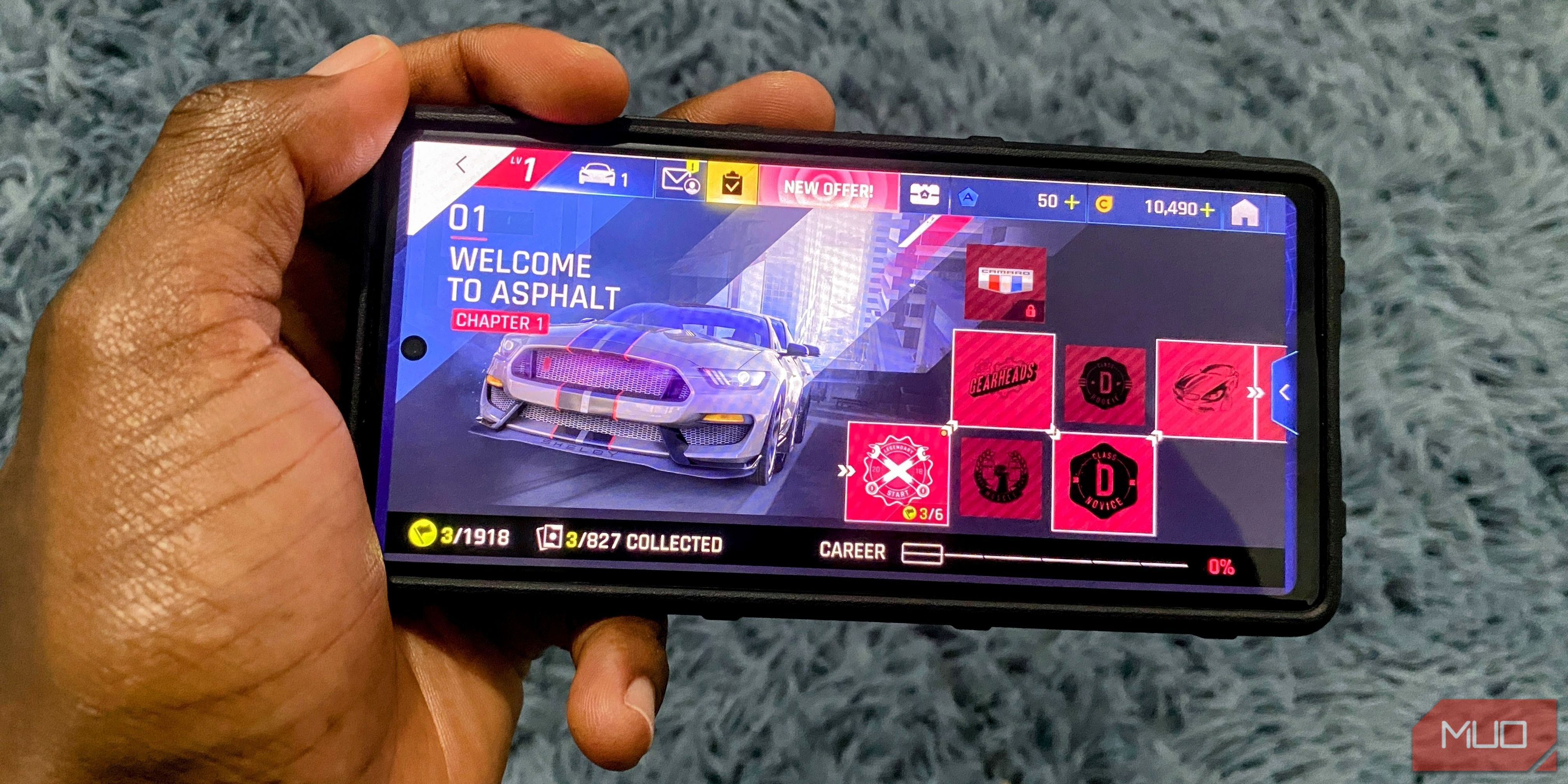 Cầm điện thoại Android với màn hình chính của trò chơi đua xe Asphalt 9: Legends