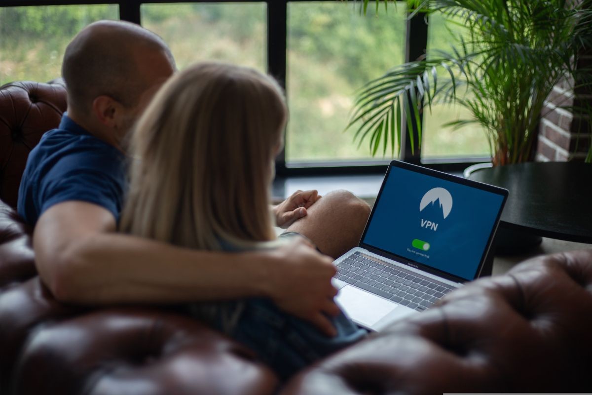 Cặp đôi ngồi và nhìn vào máy tính xách tay với VPN trên màn hình