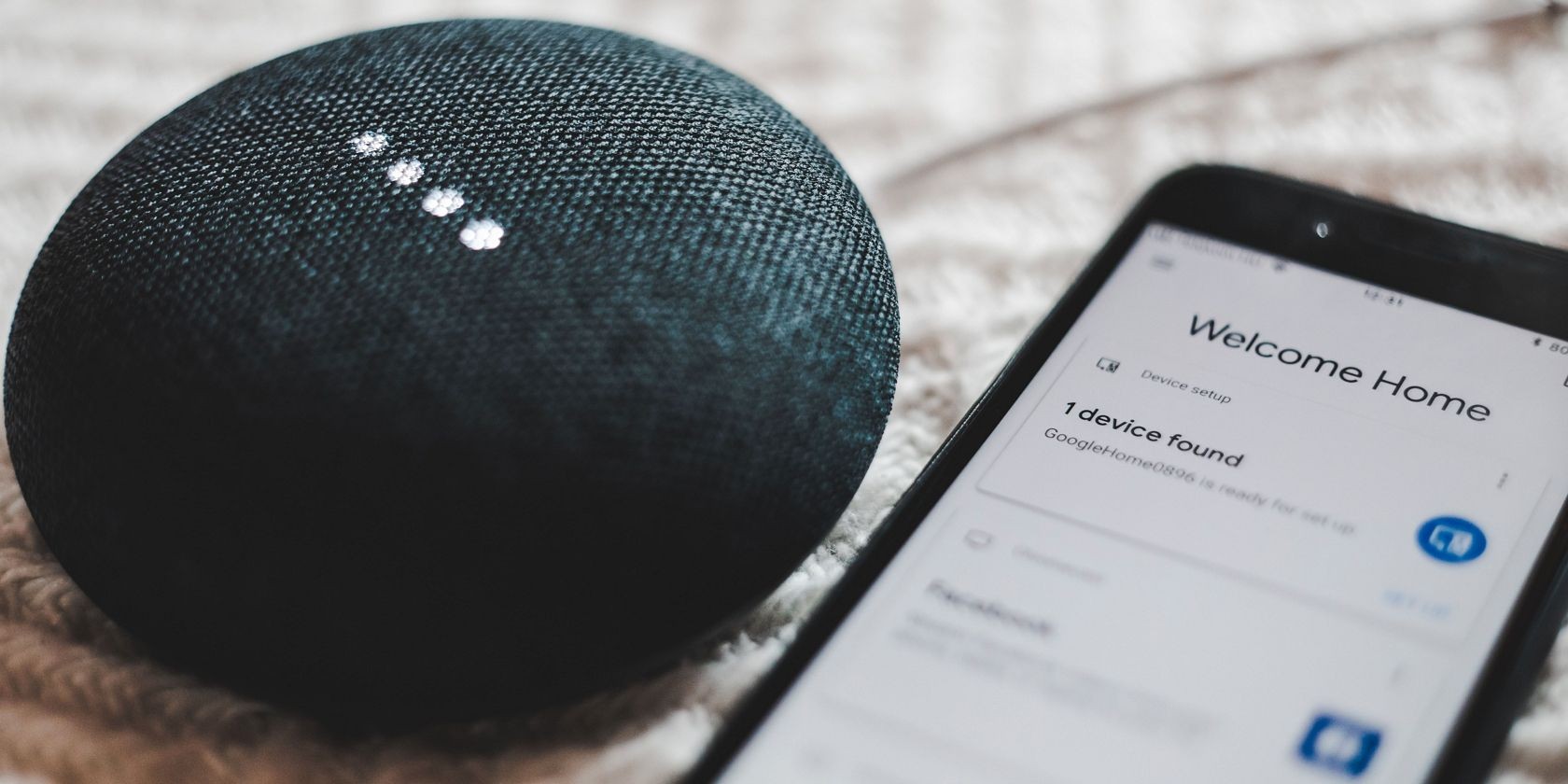 Điện thoại hiển thị Google Assistant bên cạnh Google Nest Mini