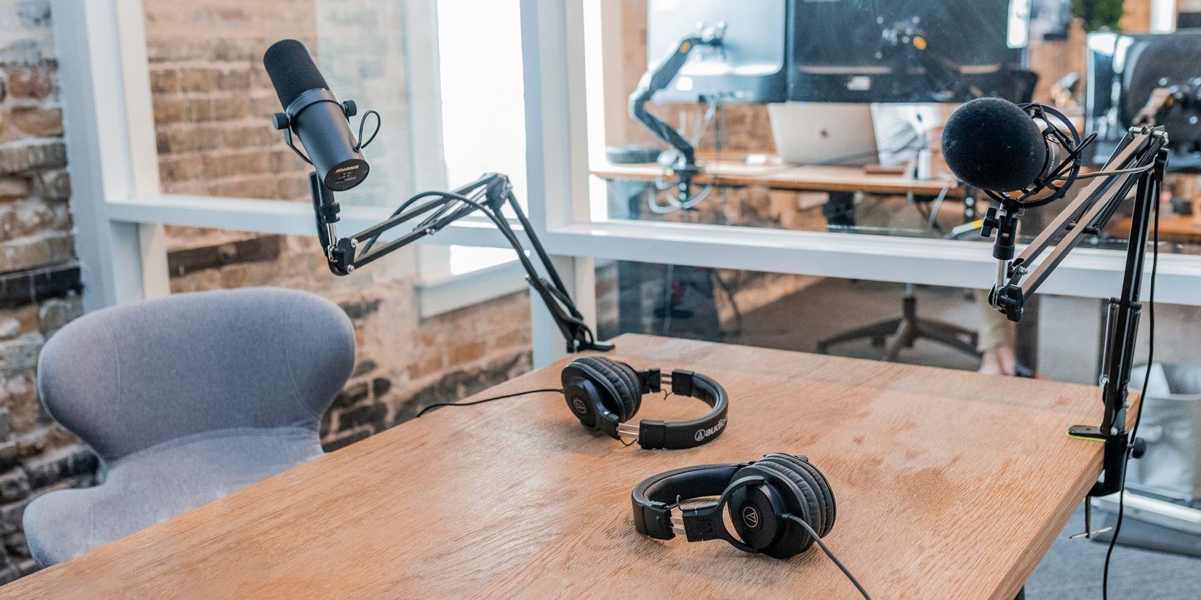 Hai microphone đen trên bàn làm việc trong phòng thu podcast