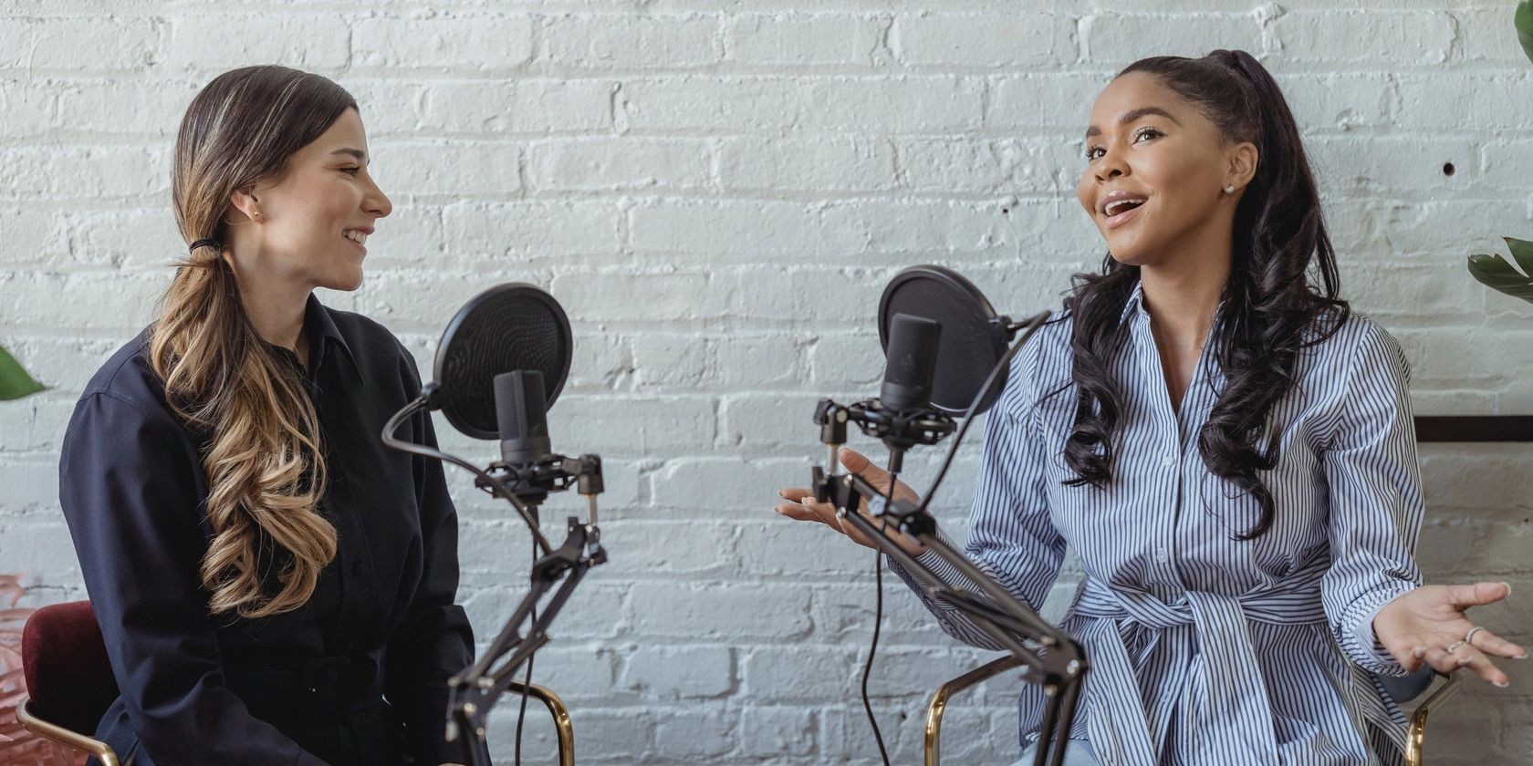 Hai phụ nữ ngồi cạnh nhau nói chuyện trên podcast