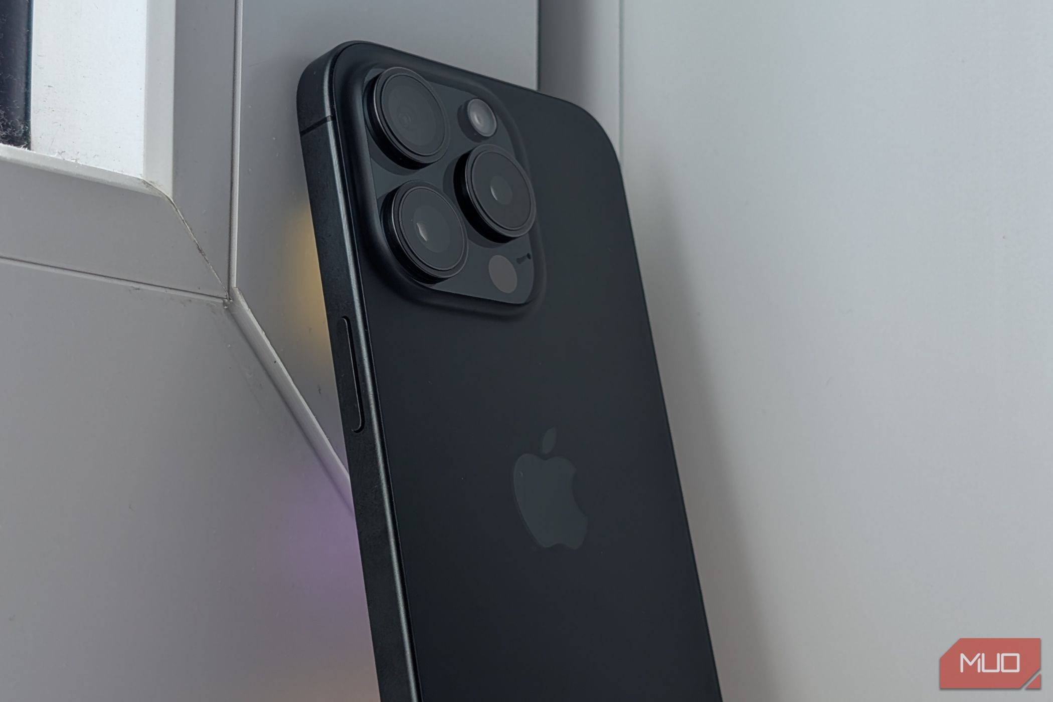 iPhone 15 Pro placed against a white wall