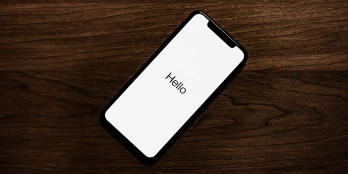 Iphone trên bề mặt gỗ hiển thị màn hình chào mừng