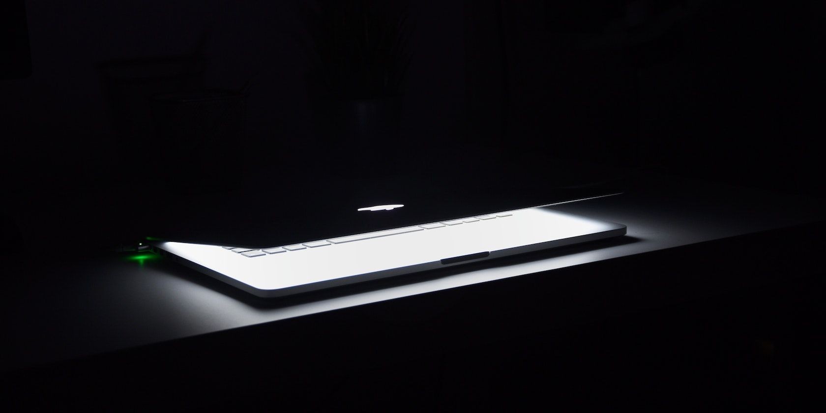 MacBook nửa đóng sáng trong phòng tối