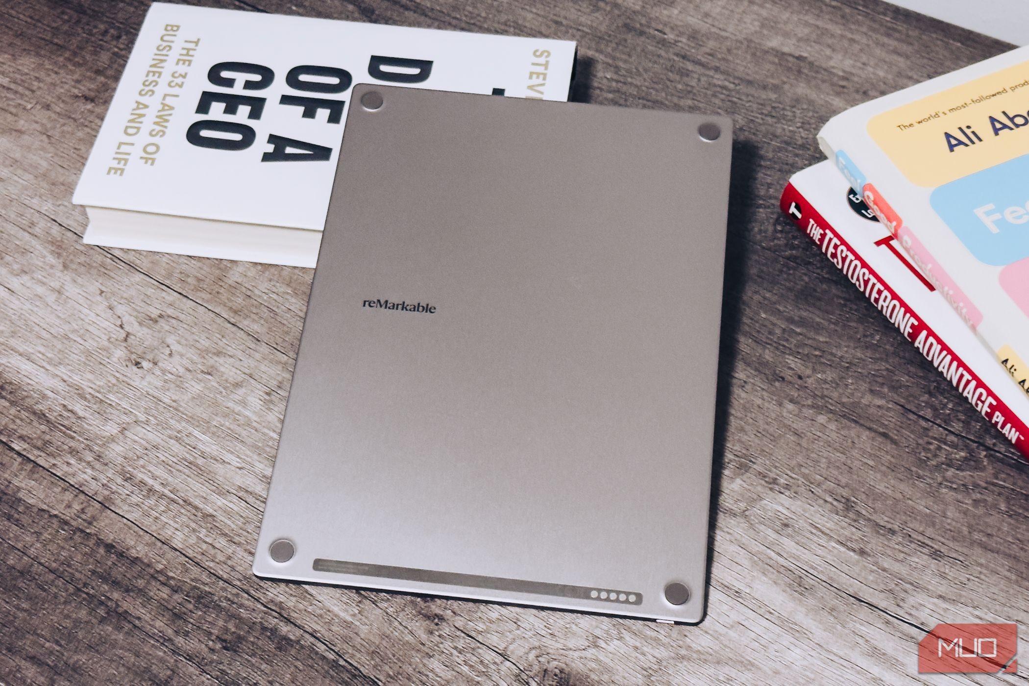 Mặt sau của reMarkable Paper Pro trên bàn gỗ bên cạnh sách