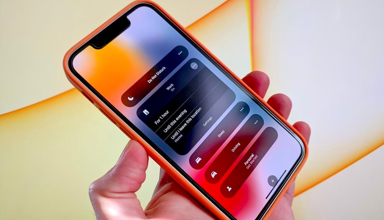 Một bàn tay cầm iPhone với menu tập trung trên màn hình
