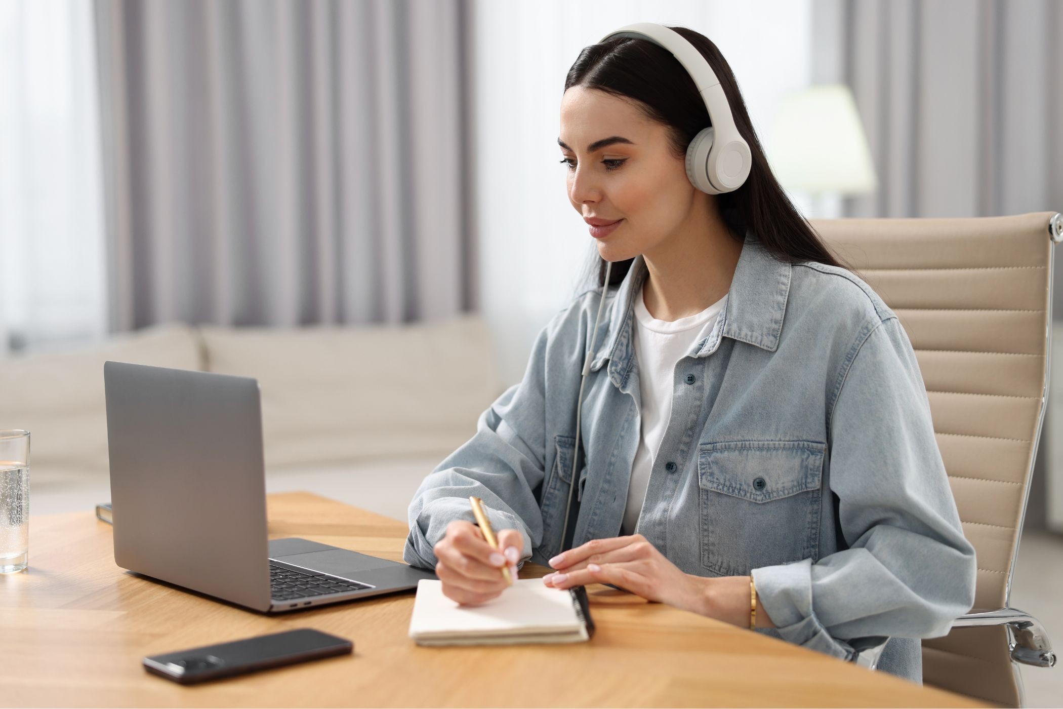 một phụ nữ đang sử dụng laptop với tai nghe