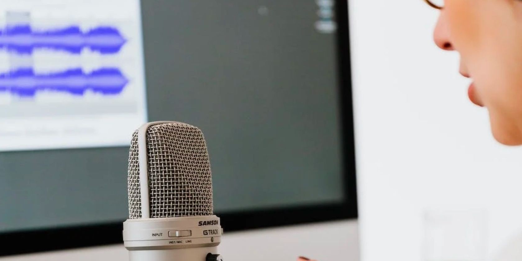 Một phụ nữ ngồi trước microphone và máy tính
