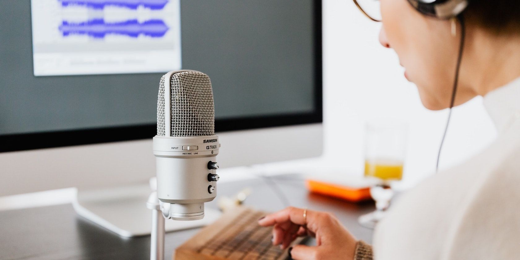 Một phụ nữ nói vào micro để ghi âm podcast
