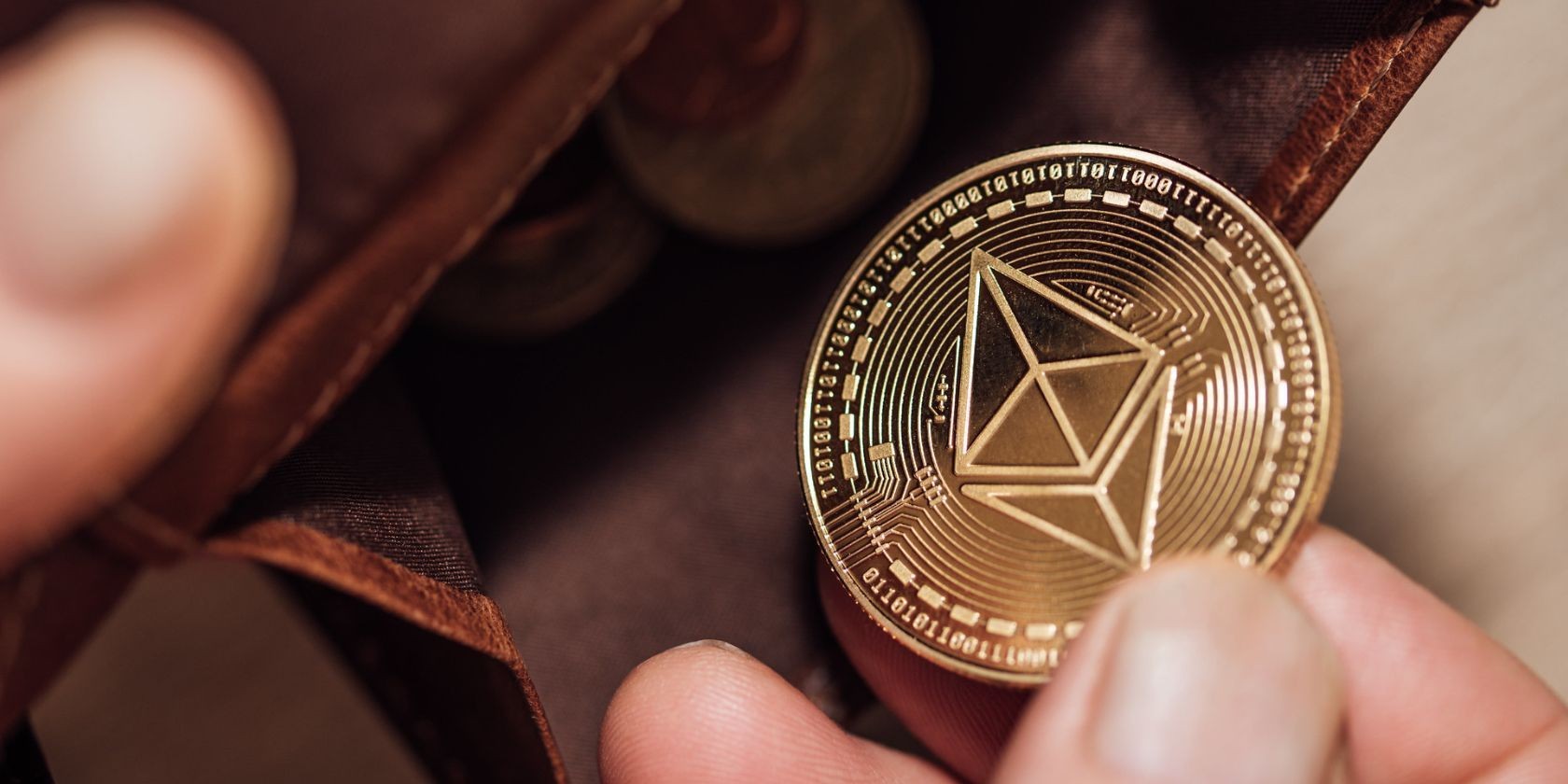 Người cầm ví da nâu và đồng Ethereum