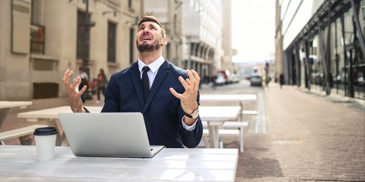 Người đàn ông bực bội trước máy tính xách tay