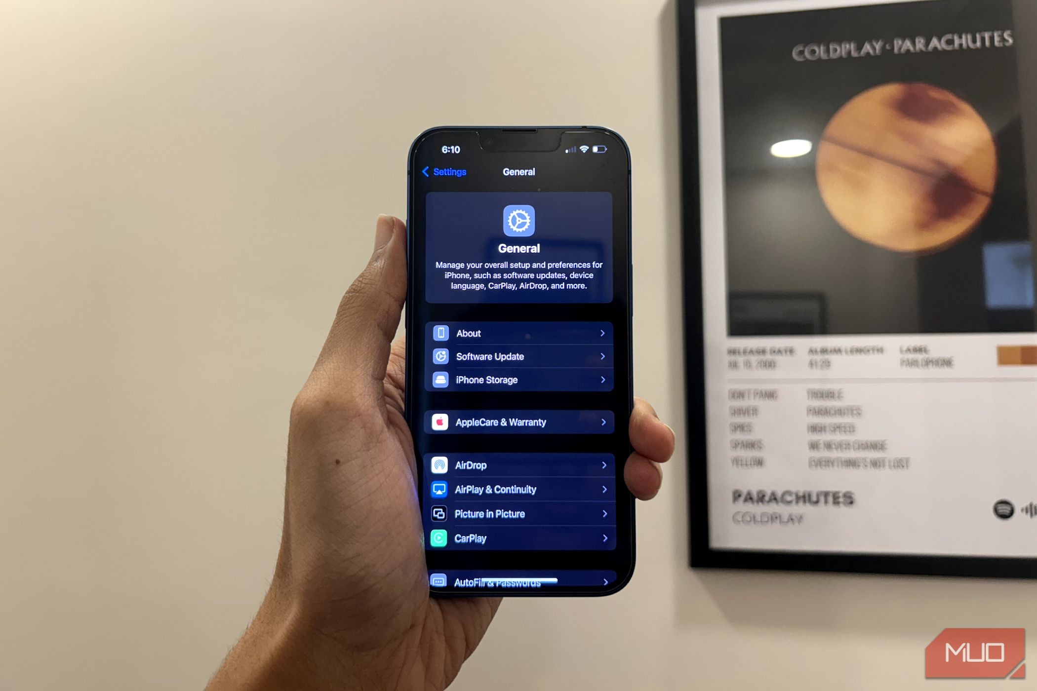 Người đàn ông cầm iPhone hiển thị ứng dụng Settings được thiết kế lại trong iOS 18