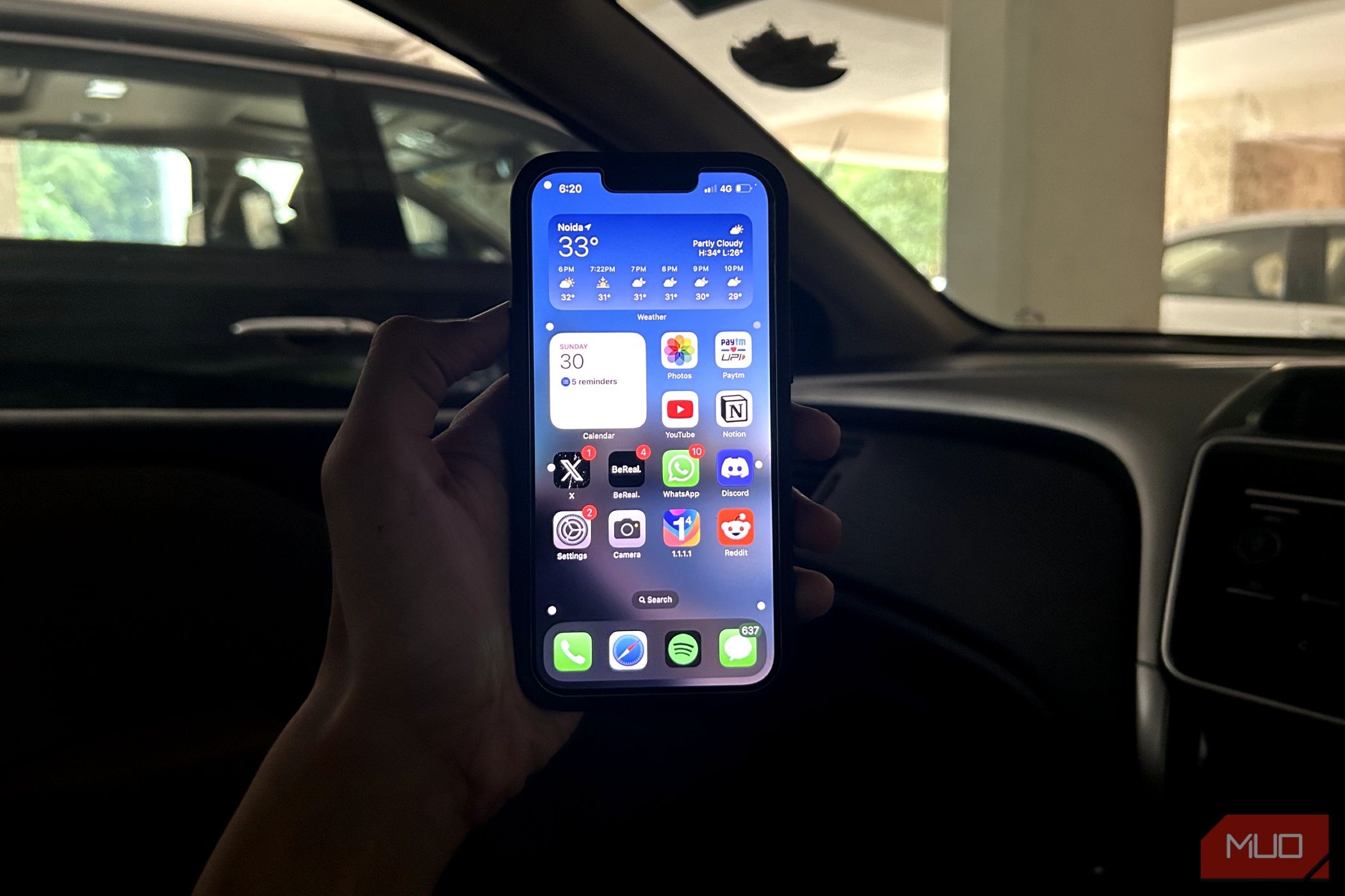 Người đàn ông cầm iPhone trong xe hơi với Vehicle Motion Cues được bật