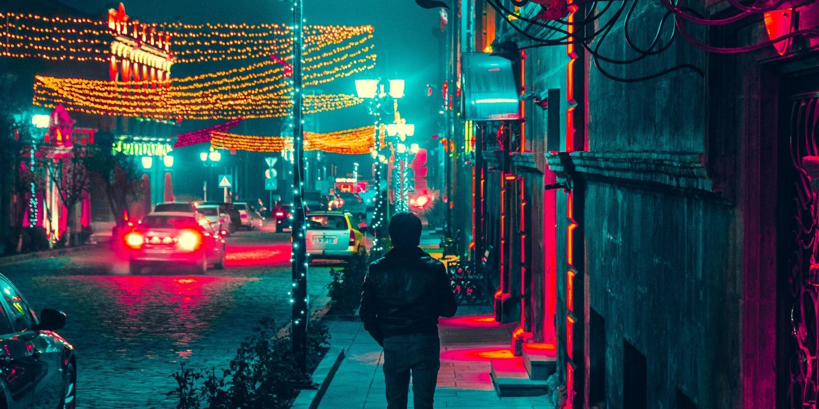 Người đàn ông đi bộ dọc vỉa hè vào ban đêm