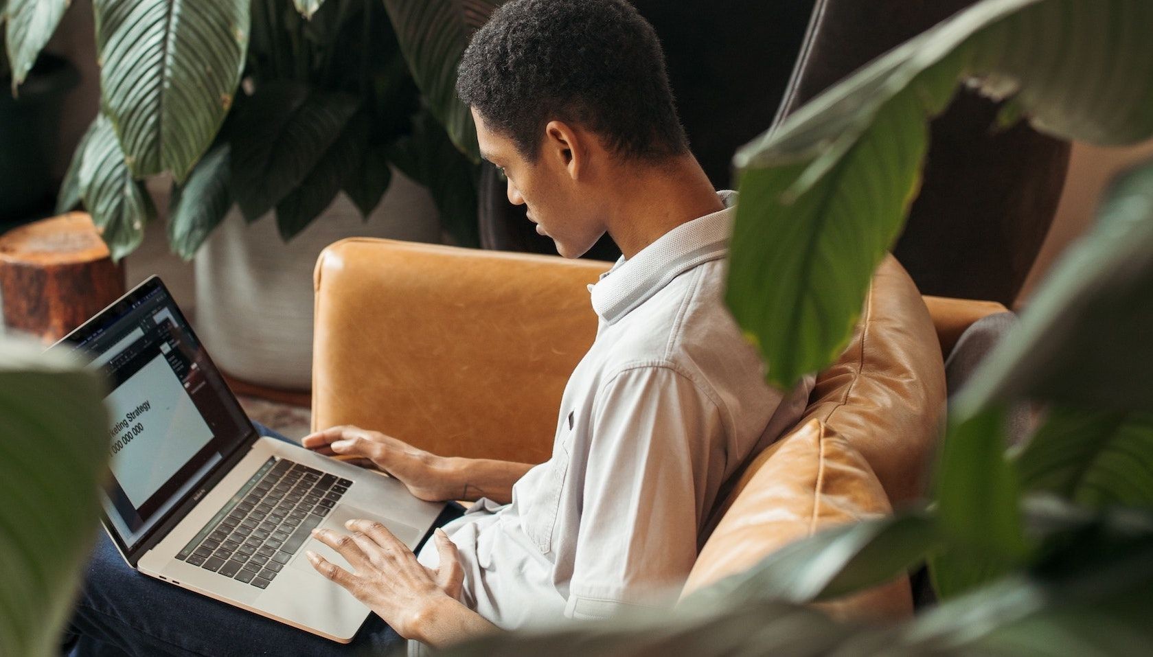Người đàn ông làm việc trên laptop trên đùi
