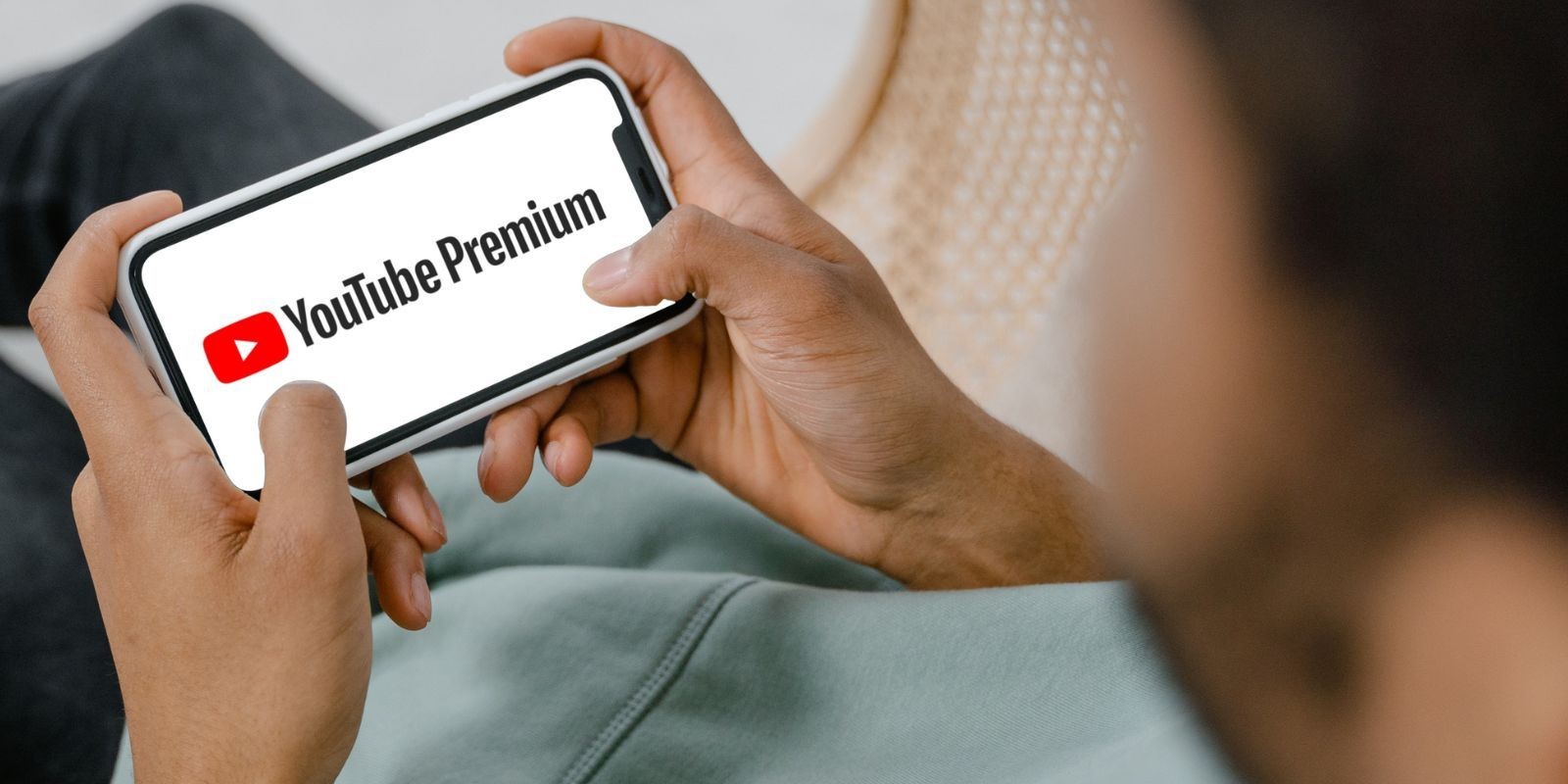 Người đàn ông ngồi xem YouTube Premium trên điện thoại di động