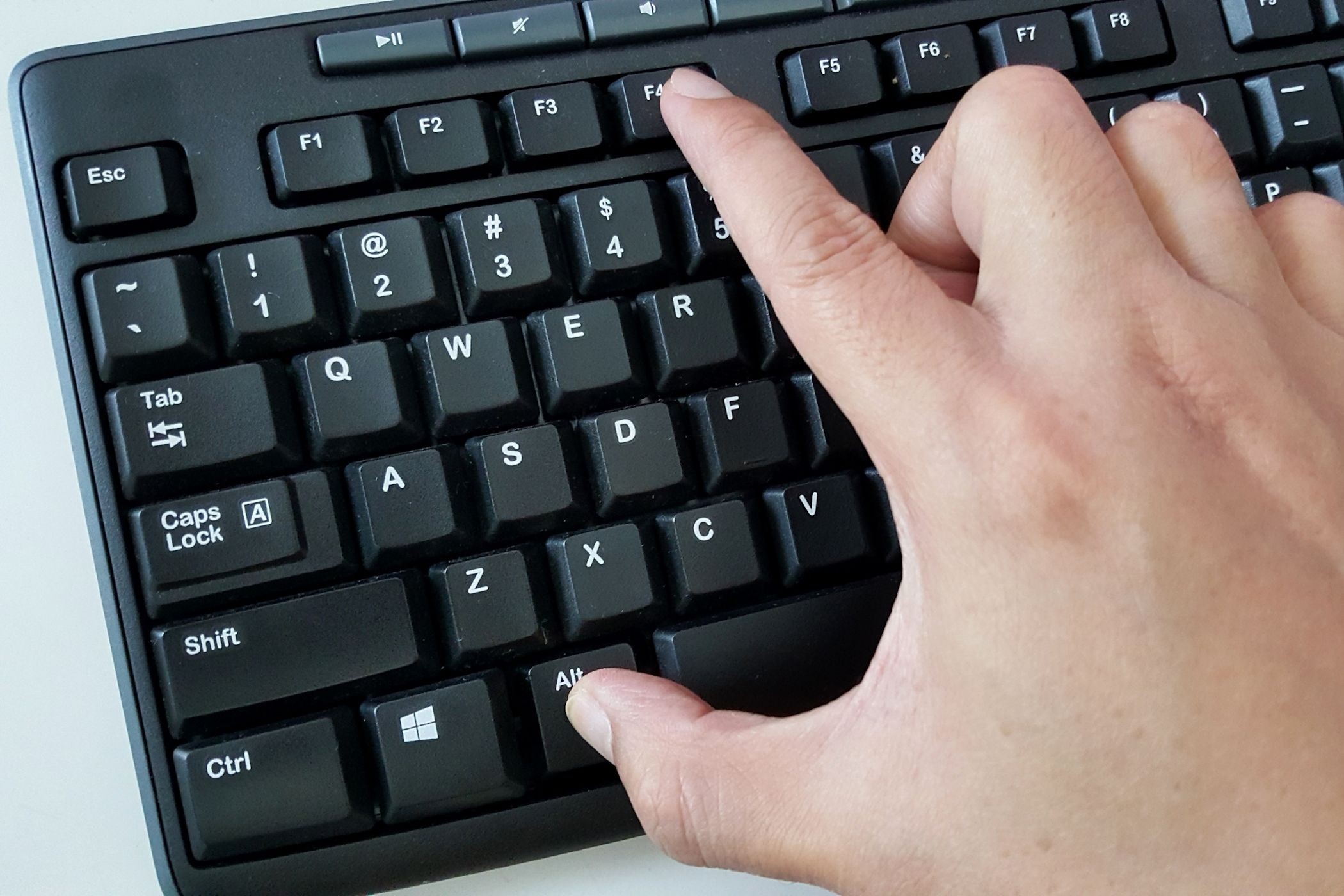 Người đàn ông nhấn phím Alt và F4 trên bàn phím Windows