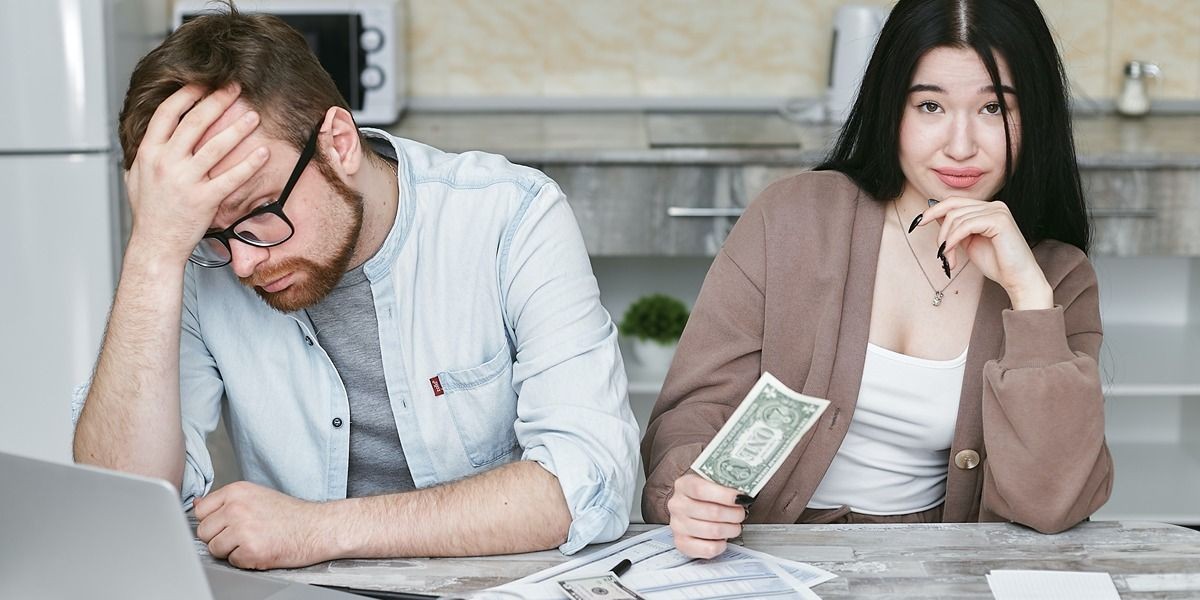 Người đàn ông và phụ nữ bên máy tính với tiền