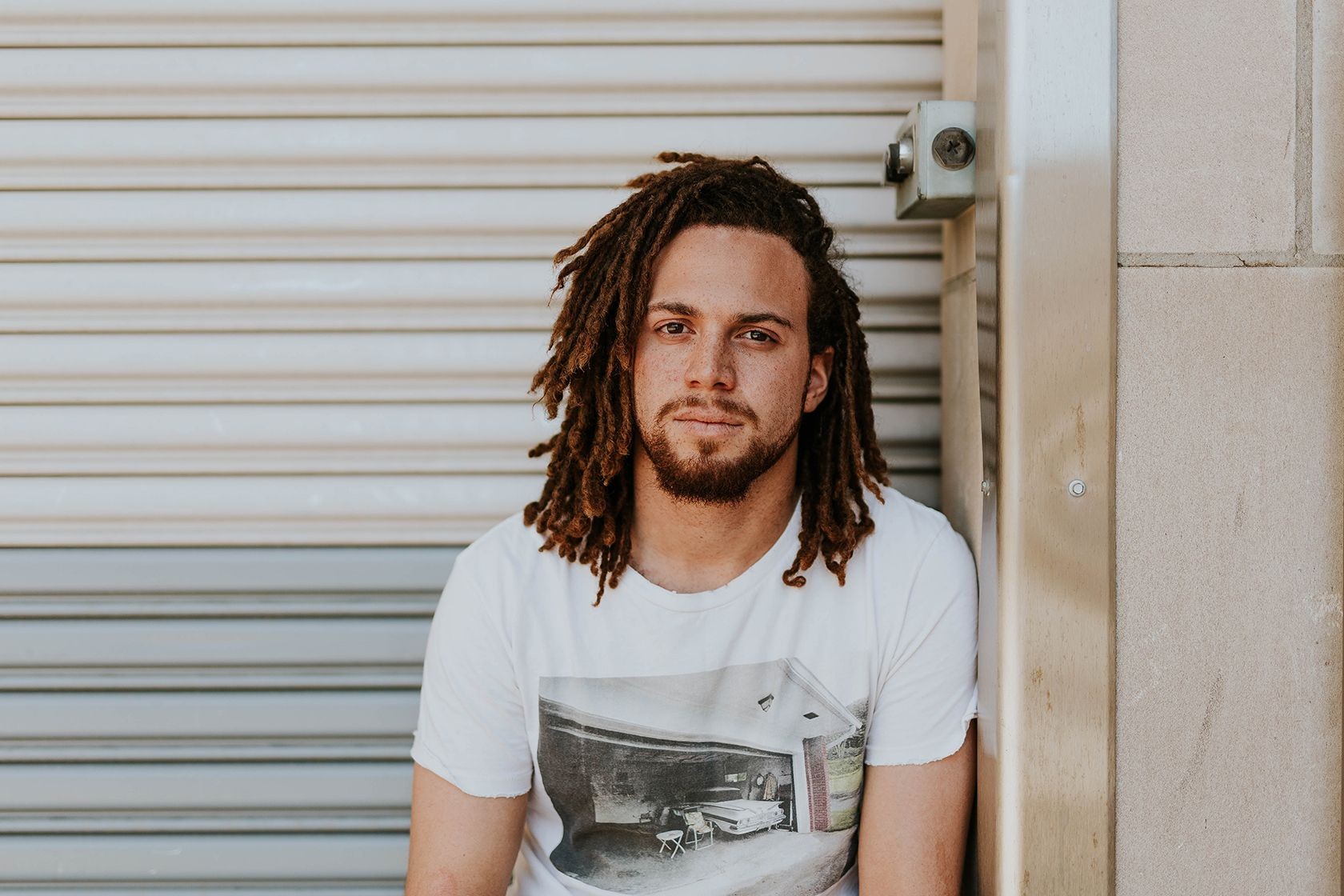 Người đàn ông với tóc dreadlocks nhìn vào máy ảnh