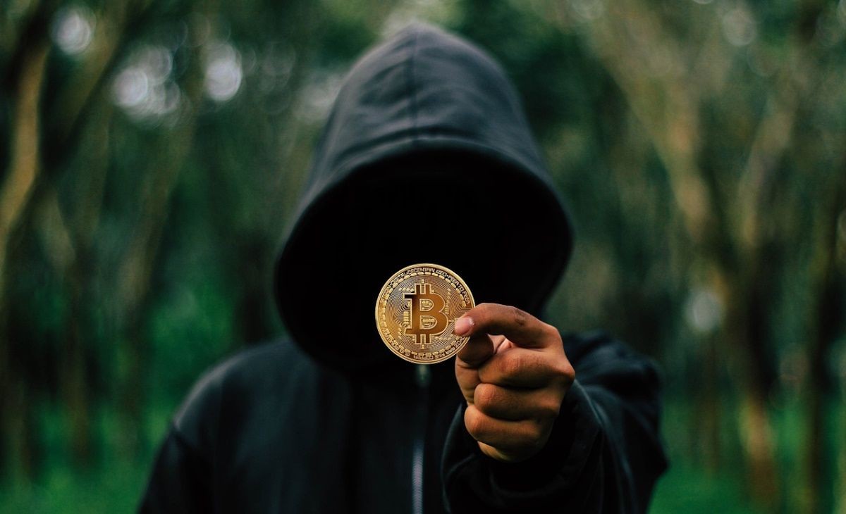 Người đeo áo khoác đang cầm Bitcoin vàng