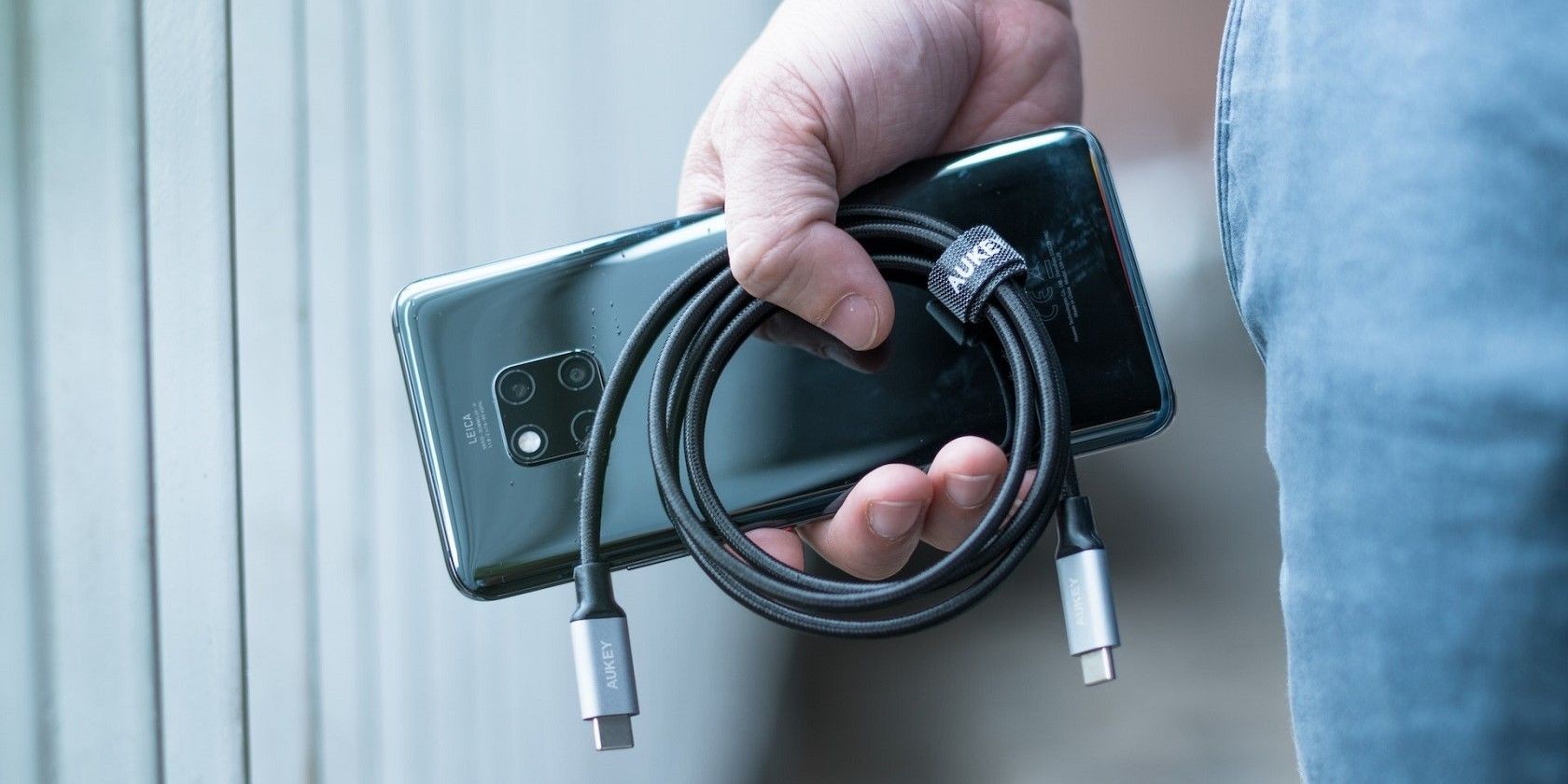 Người dùng với điện thoại thông minh hiện đại và cáp USB
