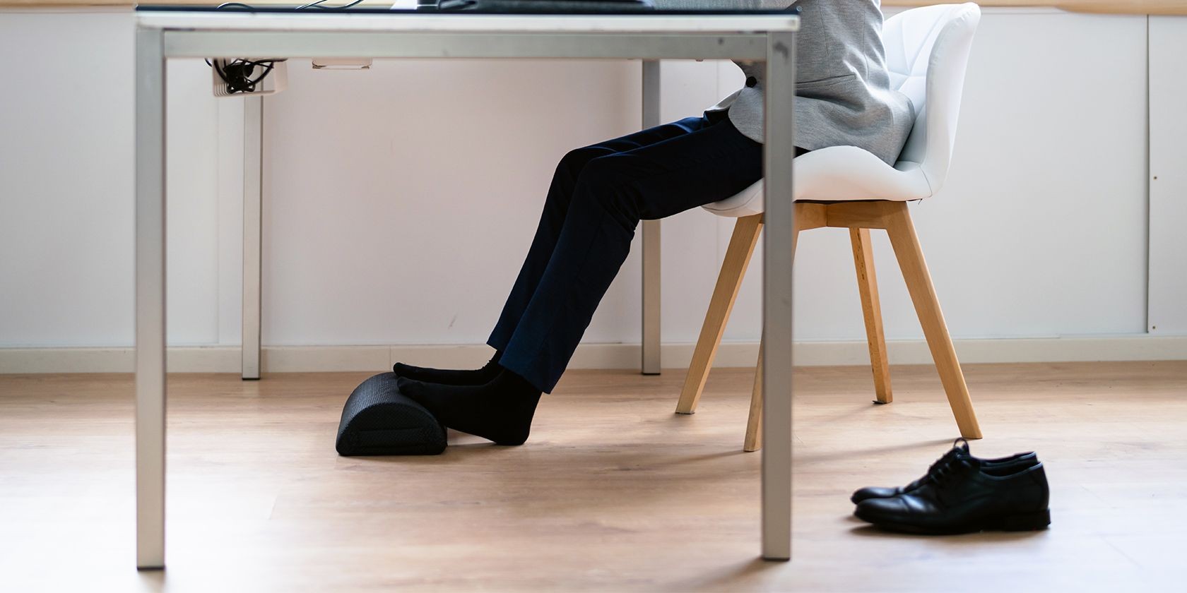 Người ngồi trên ghế với chân đặt trên đỡ chân