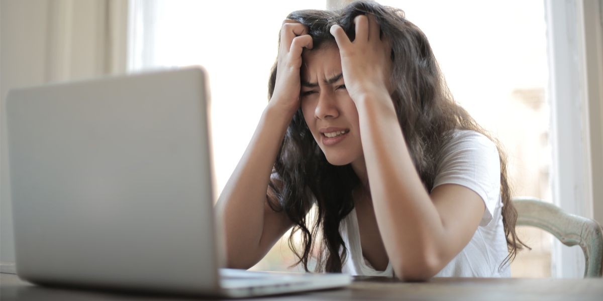 Người phụ nữ bực bội khi làm việc trên máy tính xách tay