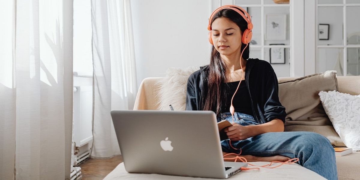 Người phụ nữ sử dụng máy tính xách tay với tai nghe