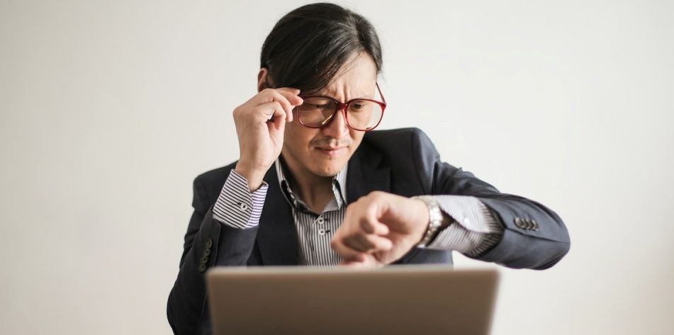 Người trong bộ vest kiểm tra đồng hồ đeo tay