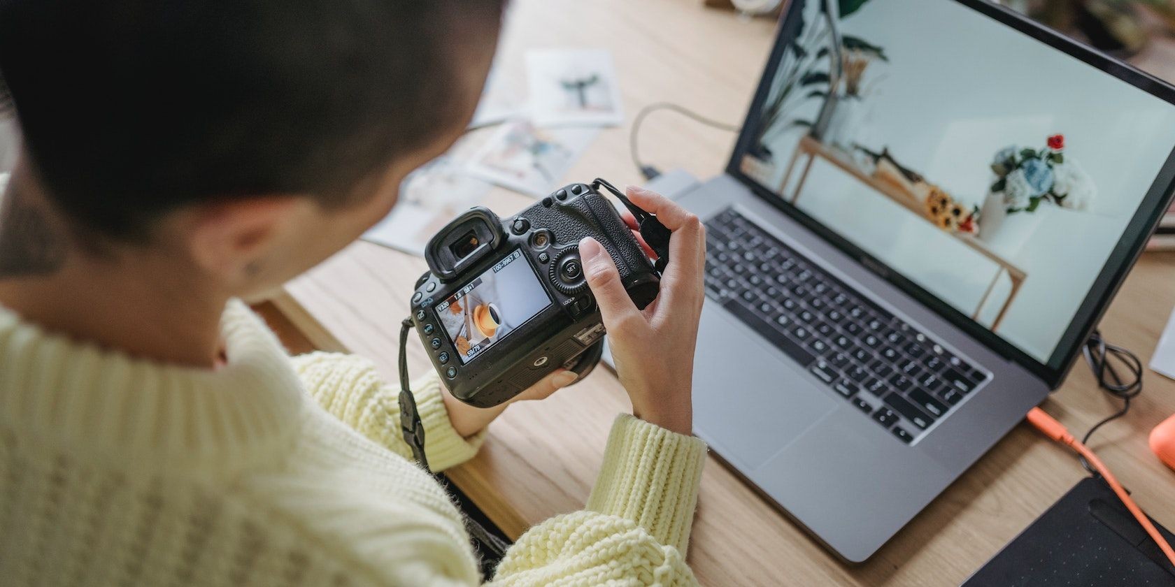 Nhiếp ảnh gia xem ảnh trên máy ảnh và laptop