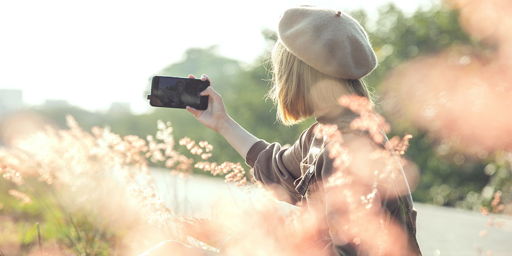 Phụ nữ trong cánh đồng đang chụp selfie bằng điện thoại