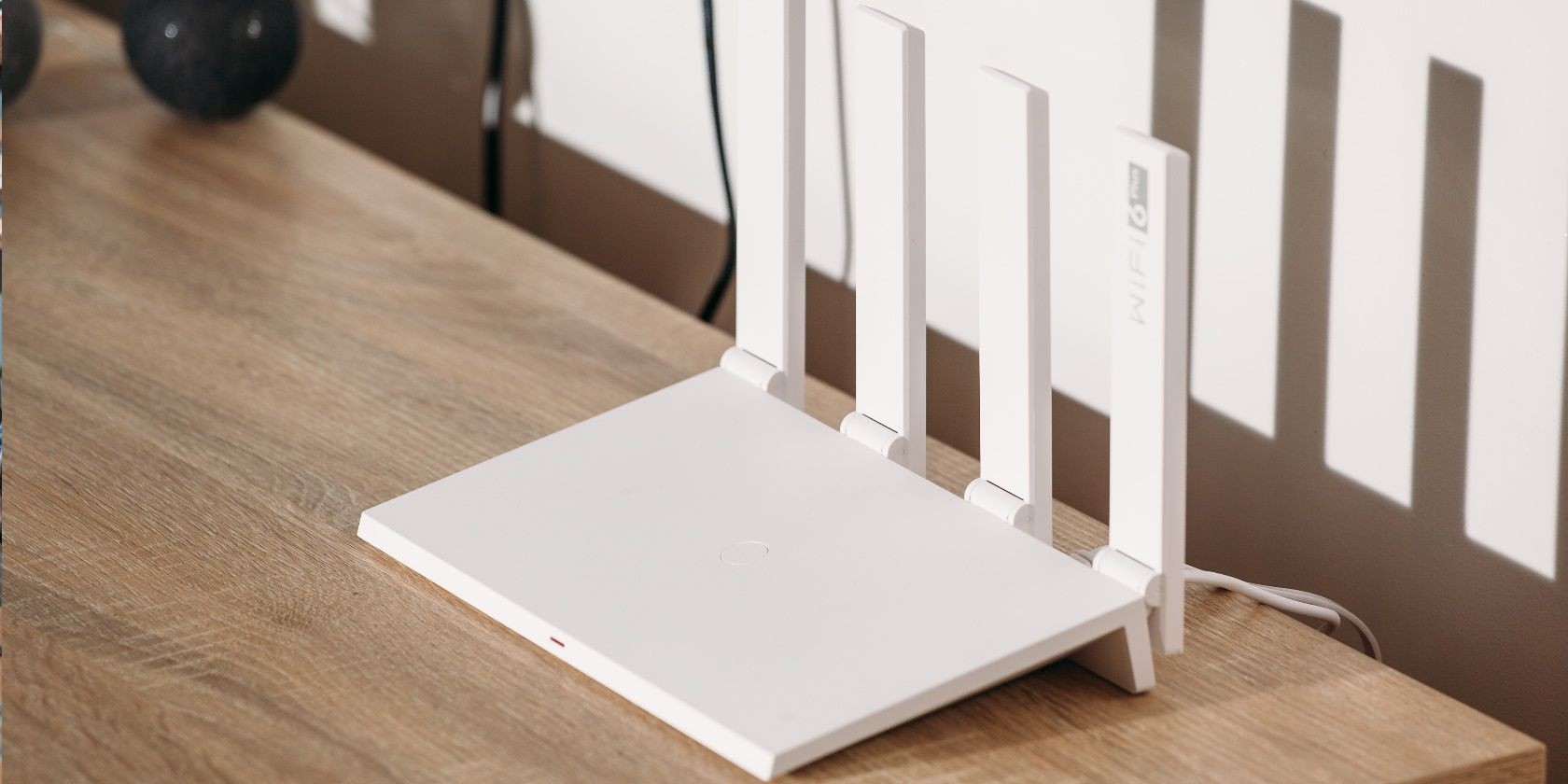 Router Wi-Fi 6 trắng với 4 ăng-ten trên bàn gỗ